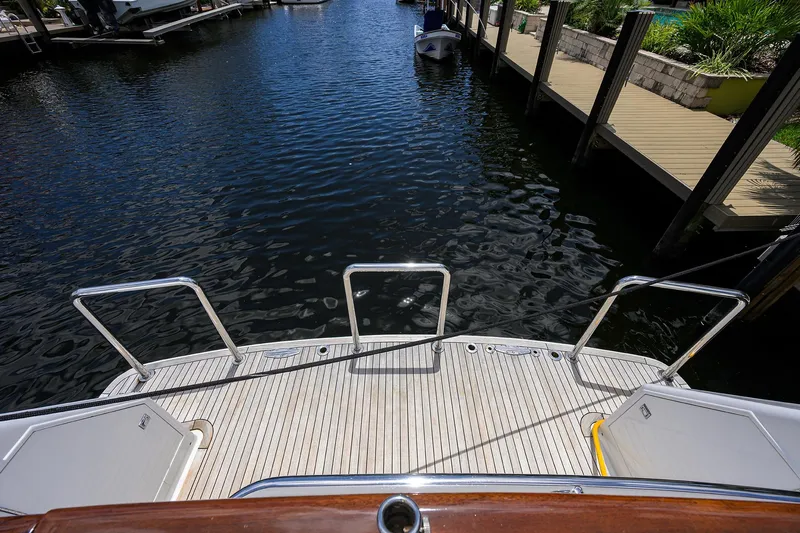 Change Of Latitude Yacht Photos Pics Ocean Alexander 602 yacht stern view, docked, showcasing swim platform and water.