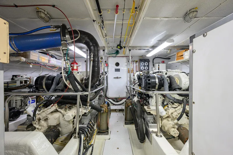 Change Of Latitude Yacht Photos Pics Engine room of 2001 Ocean Alexander 602 yacht, featuring dual engines and complex piping system.