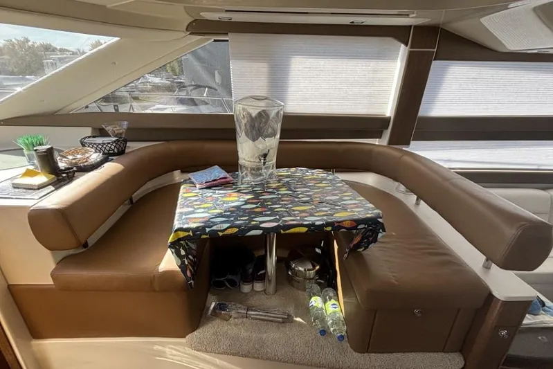 Bad Boy VI Yacht Photos Pics Interior of 2016 Meridian 441 Sedan yacht with cozy seating and table setup.