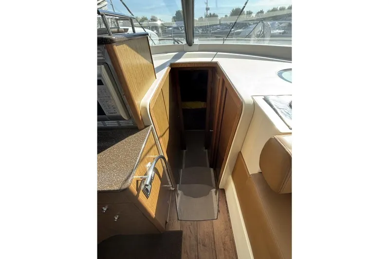 Bad Boy VI Yacht Photos Pics Interior view of 2016 Meridian 441 Sedan yacht, featuring stairs and wooden cabinetry.