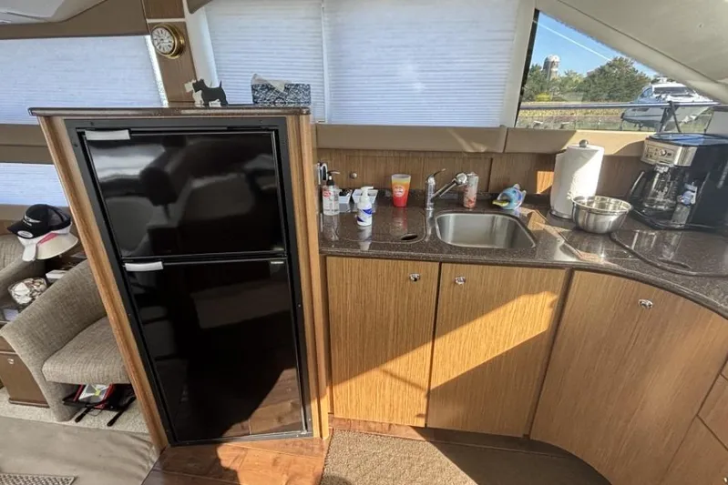Bad Boy VI Yacht Photos Pics Interior of 2016 Meridian 441 Sedan yacht kitchen with sink, fridge, and coffee maker.