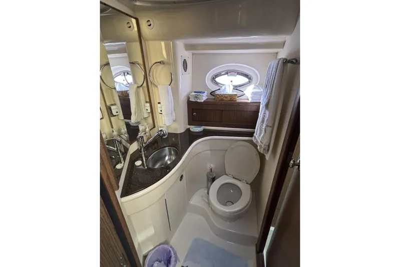 Bad Boy VI Yacht Photos Pics Bathroom interior of 2016 Meridian 441 Sedan yacht, featuring sink, toilet, and porthole window.