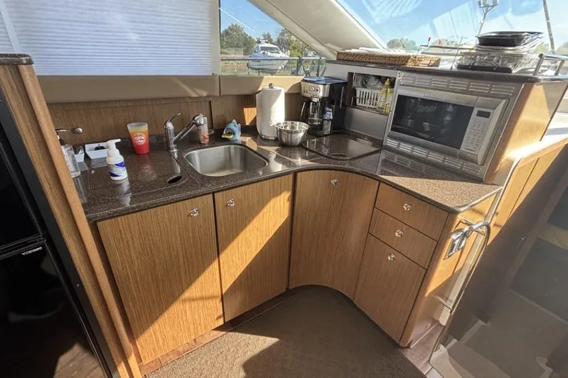 Bad Boy VI Yacht Photos Pics 2016 Meridian 441 Sedan yacht kitchen with sink, microwave, and wooden cabinetry.