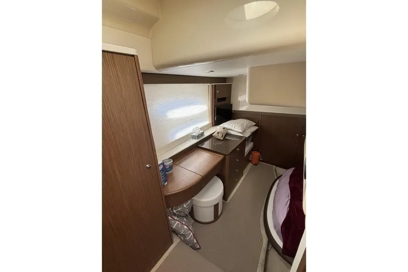 Bad Boy VI Yacht Photos Pics Interior of 2016 Meridian 441 Sedan yacht cabin with wooden furnishings and cozy bedding.