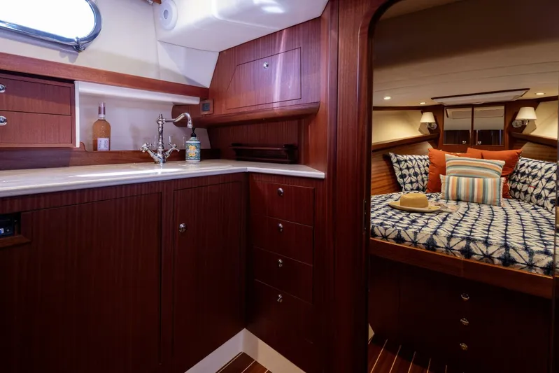  Yacht Photos Pics Luxurious 2022 Fratelli Aprea 32 Hard Top yacht interior with wood finish and cozy bedroom.