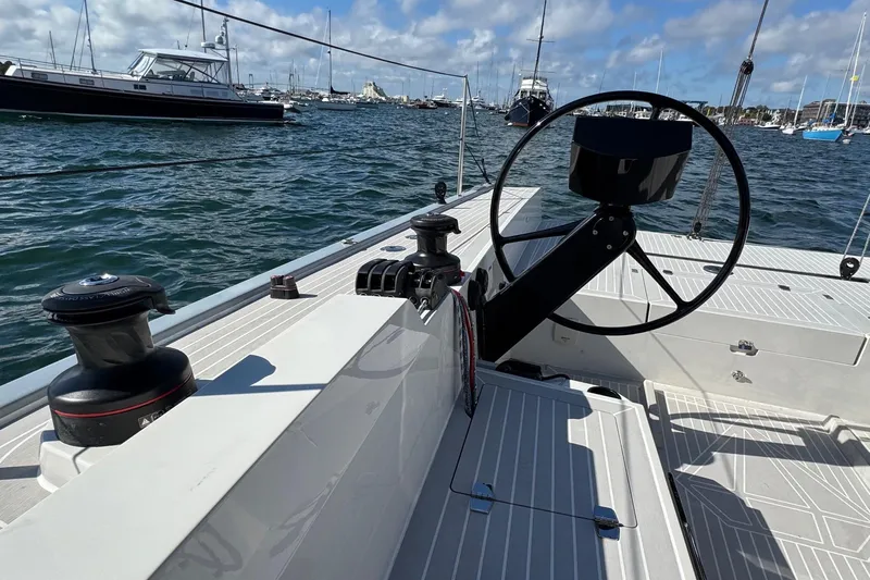 Sortie Yacht Photos Pics 2023 Saffier 33 Life sailboat cockpit with steering wheel and winch, docked in a marina.