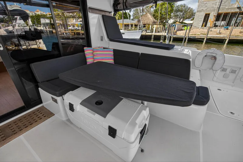 Seaquinn Yacht Photos Pics Outdoor seating area on a 2019 Lagoon 42 catamaran with cushions and a table.