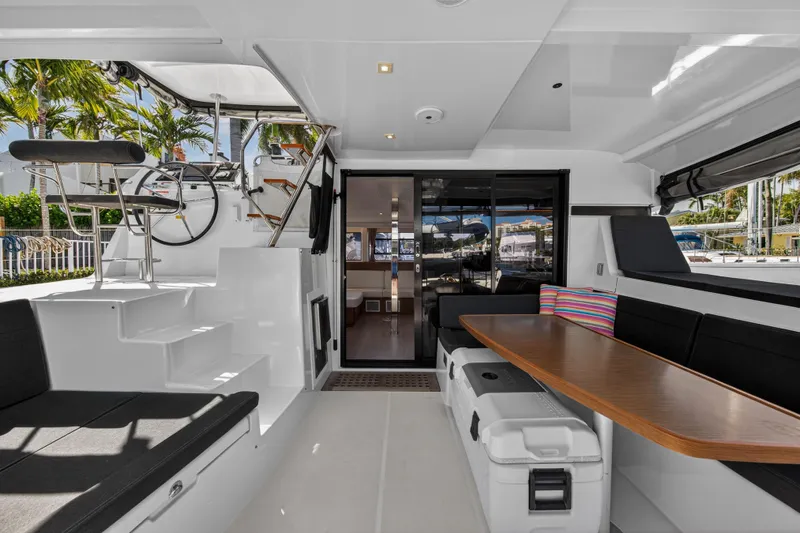 Seaquinn Yacht Photos Pics 2019 Lagoon 42 yacht interior with seating, table, and helm station.
