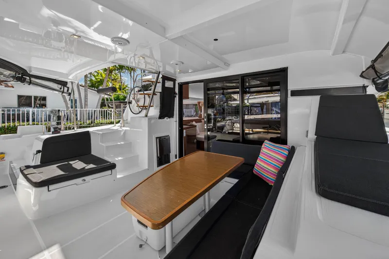 Seaquinn Yacht Photos Pics 2019 Lagoon 42 yacht interior with seating, table, and helm station.