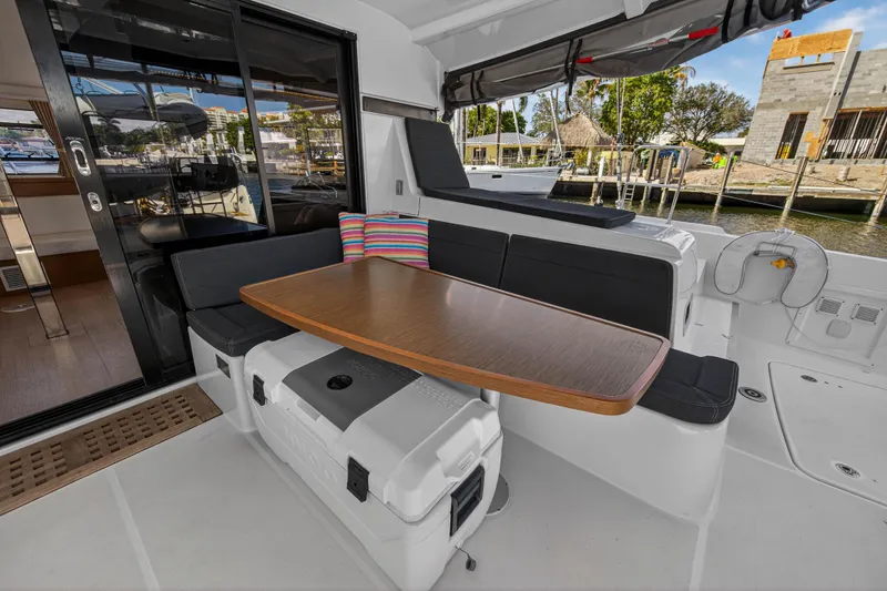 Seaquinn Yacht Photos Pics 2019 Lagoon 42 yacht cockpit with seating, table, and colorful pillow.
