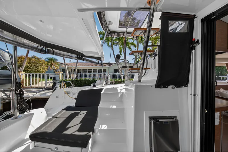 Seaquinn Yacht Photos Pics 2019 Lagoon 42 catamaran cockpit with seating, stairs, and tropical marina view.