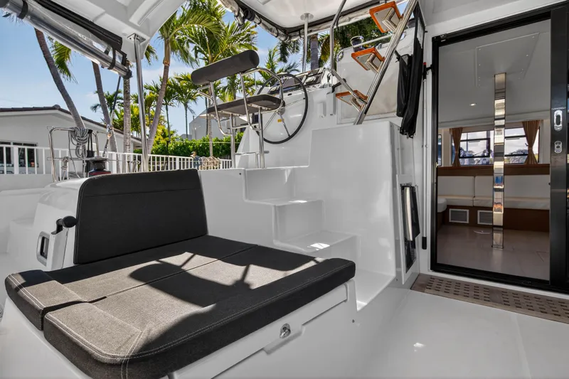 Seaquinn Yacht Photos Pics 2019 Lagoon 42 catamaran cockpit with seating, steering wheel, and view of interior.