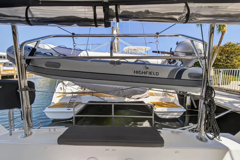Seaquinn Yacht Photos Pics 2019 Lagoon 42 catamaran with Highfield dinghy on davits, docked in sunny marina.