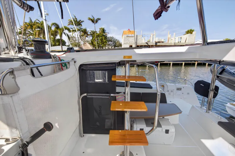 Seaquinn Yacht Photos Pics 2019 Lagoon 42 catamaran interior with wooden steps, docked near palm trees.