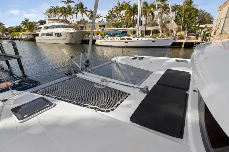 Seaquinn Yacht Photos Pics 2019 Lagoon 42 catamaran docked in a marina with palm trees and yachts.