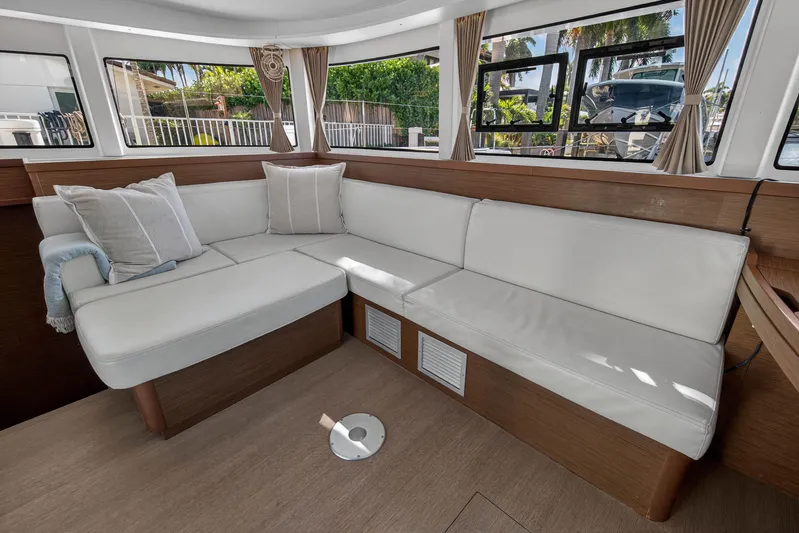 Seaquinn Yacht Photos Pics Luxurious interior of 2019 Lagoon 42 catamaran with white leather seating and large windows.