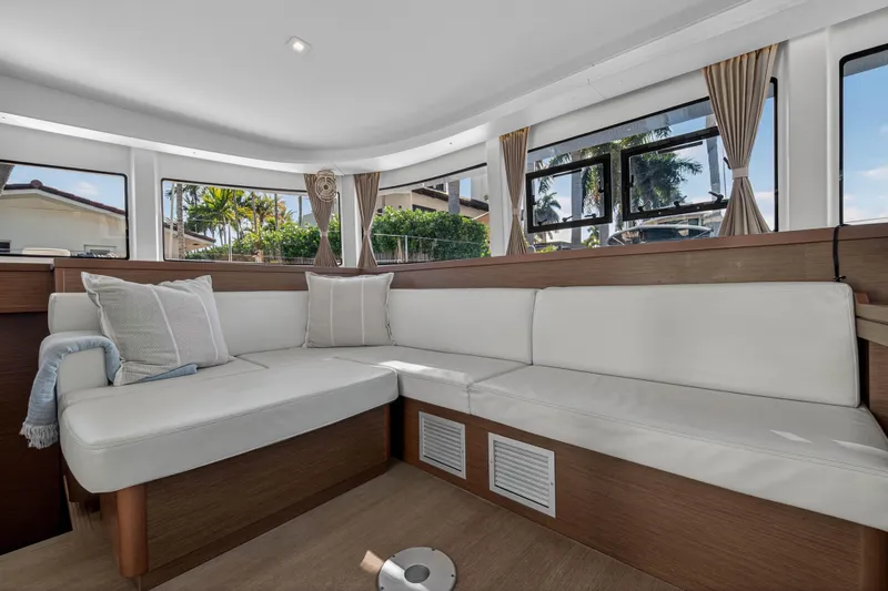 Seaquinn Yacht Photos Pics Luxurious interior of 2019 Lagoon 42 catamaran with white seating and large windows.