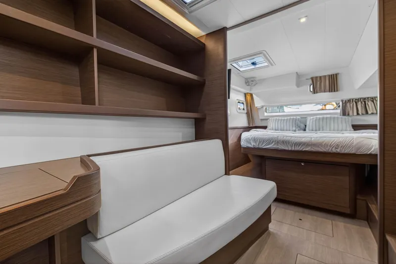 Seaquinn Yacht Photos Pics Luxurious interior of 2019 Lagoon 42 yacht with cozy bedroom and elegant wood finishes.