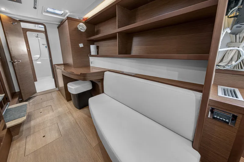 Seaquinn Yacht Photos Pics Interior of 2019 Lagoon 42 catamaran with wooden shelves, seating, and bathroom entrance.