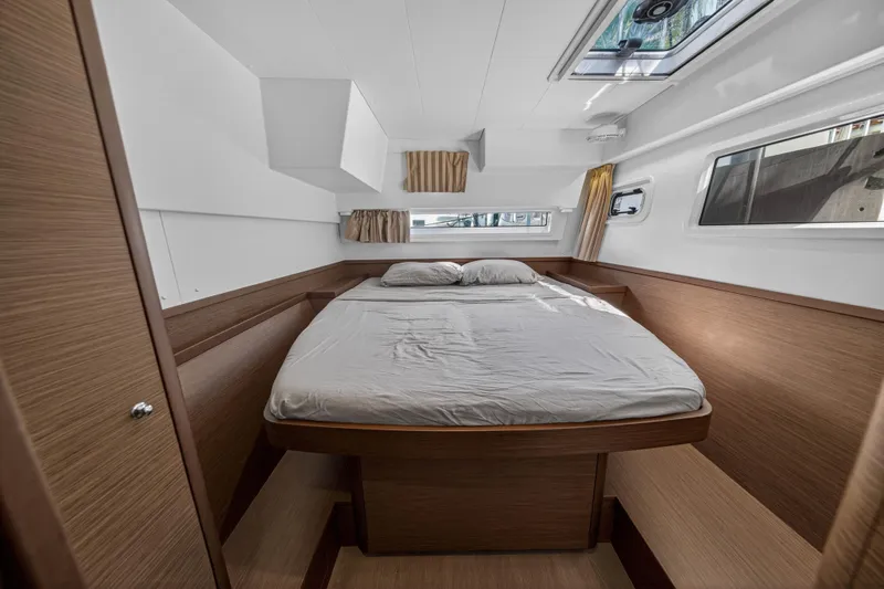 Seaquinn Yacht Photos Pics 2019 Lagoon 42 yacht cabin with a cozy bed, wooden interior, and natural light.
