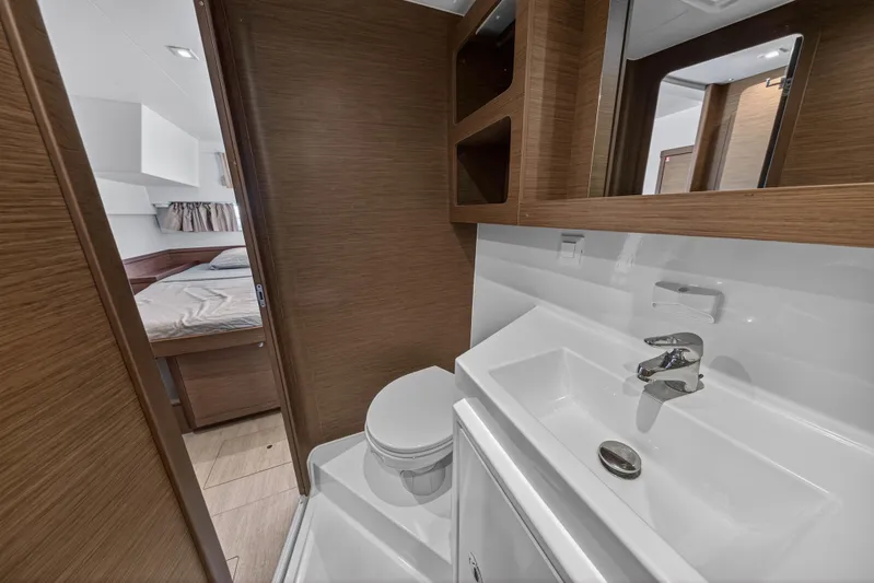 Seaquinn Yacht Photos Pics 2019 Lagoon 42 yacht bathroom with modern sink, toilet, and wooden cabinetry.