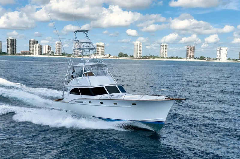 Lucky Yacht Photos Pics 1983 Rybovich 55 Convertible yacht cruising near city skyline.