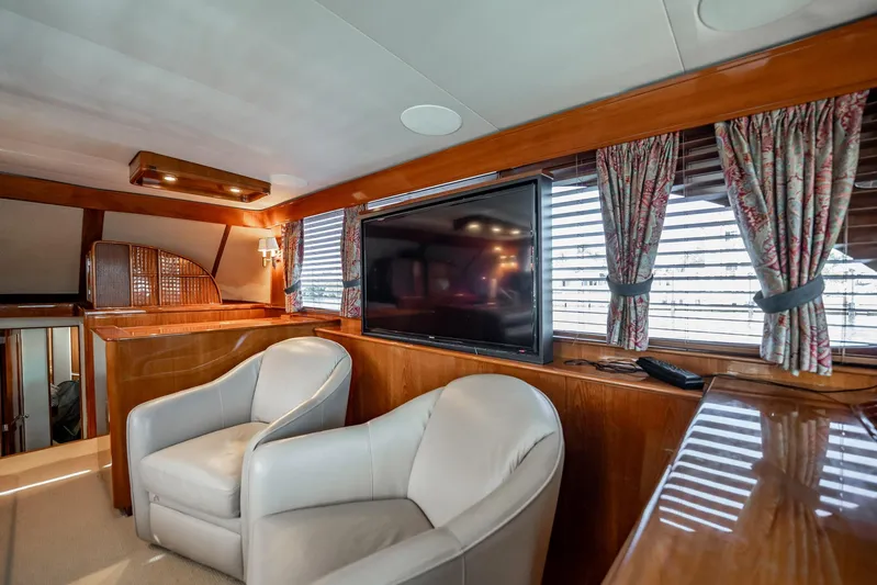 Lucky Yacht Photos Pics Luxurious interior of 1983 Rybovich 55 Convertible yacht with leather chairs and large TV.