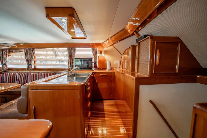 Lucky Yacht Photos Pics Interior of 1983 Rybovich 55 Convertible yacht with wooden cabinetry and striped seating.