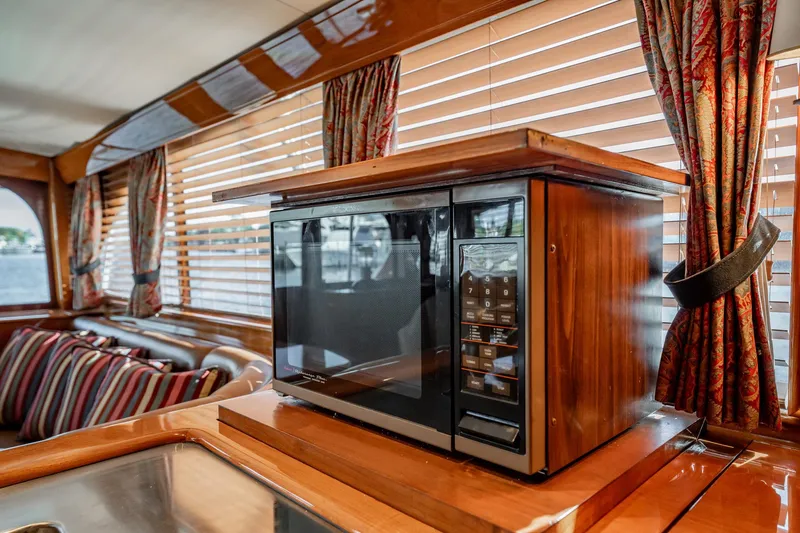 Lucky Yacht Photos Pics Luxurious interior of 1983 Rybovich 55 Convertible yacht with microwave and elegant wood finish.