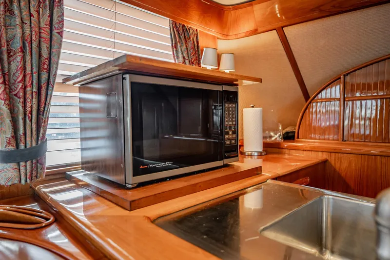 Lucky Yacht Photos Pics 1983 Rybovich 55 Convertible yacht kitchen with microwave and wooden cabinetry.