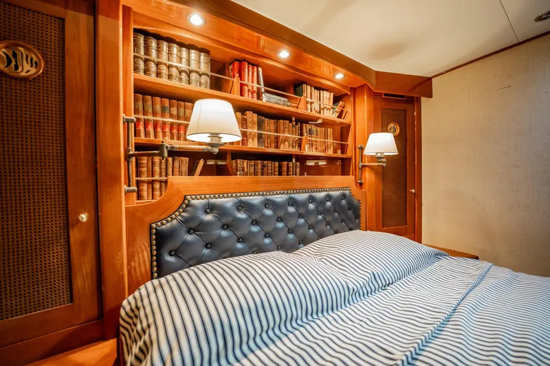 Lucky Yacht Photos Pics Luxurious 1983 Rybovich 55 Convertible yacht bedroom with elegant wood paneling and bookshelf.