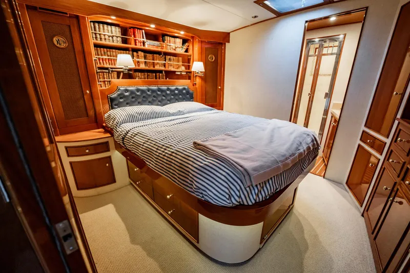 Lucky Yacht Photos Pics Luxurious bedroom interior of 1983 Rybovich 55 Convertible yacht with elegant wood finishes.