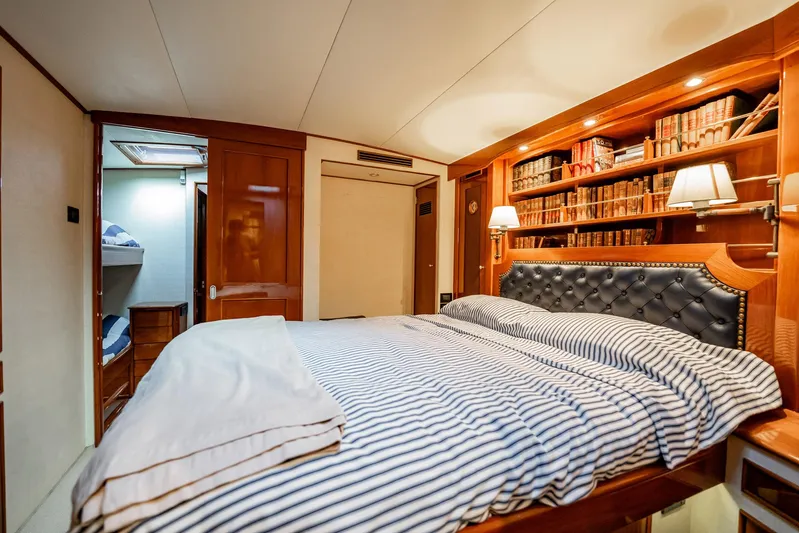 Lucky Yacht Photos Pics Luxurious cabin interior of 1983 Rybovich 55 Convertible yacht with cozy bed and bookshelf.