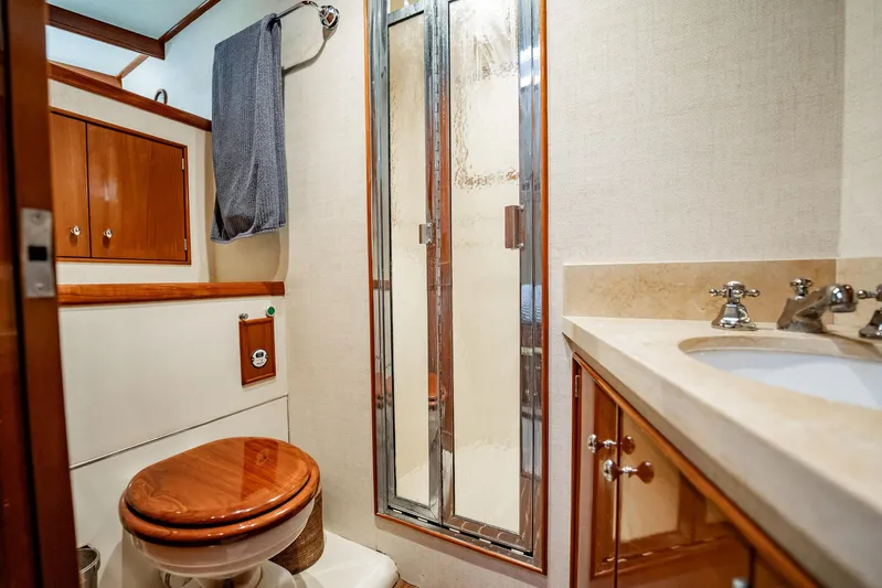 Lucky Yacht Photos Pics Luxurious bathroom in 1983 Rybovich 55 Convertible yacht with wood accents and modern fixtures.