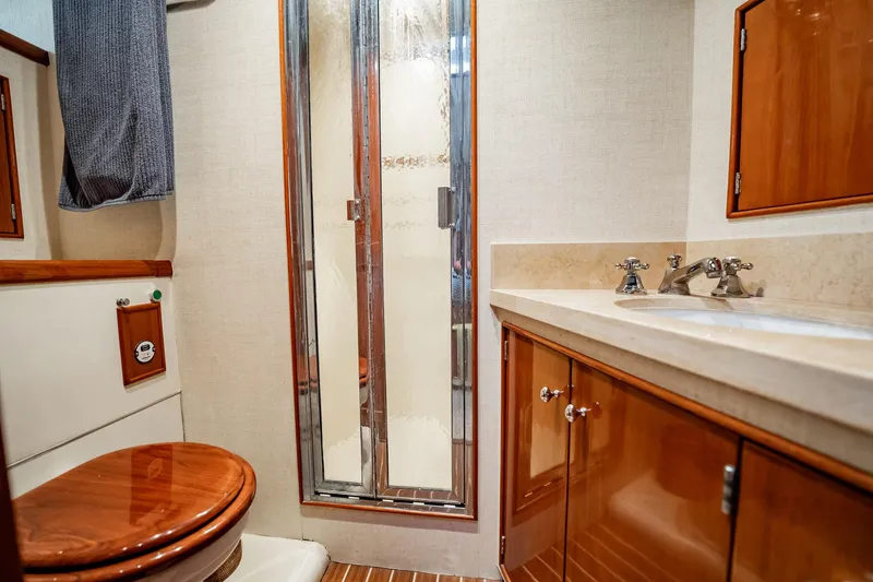 Lucky Yacht Photos Pics Luxurious bathroom interior of 1983 Rybovich 55 Convertible yacht with wood accents.