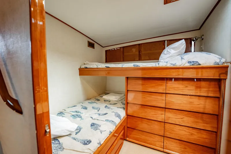 Lucky Yacht Photos Pics 1983 Rybovich 55 Convertible cabin with wooden bunk beds and nautical-themed bedding.