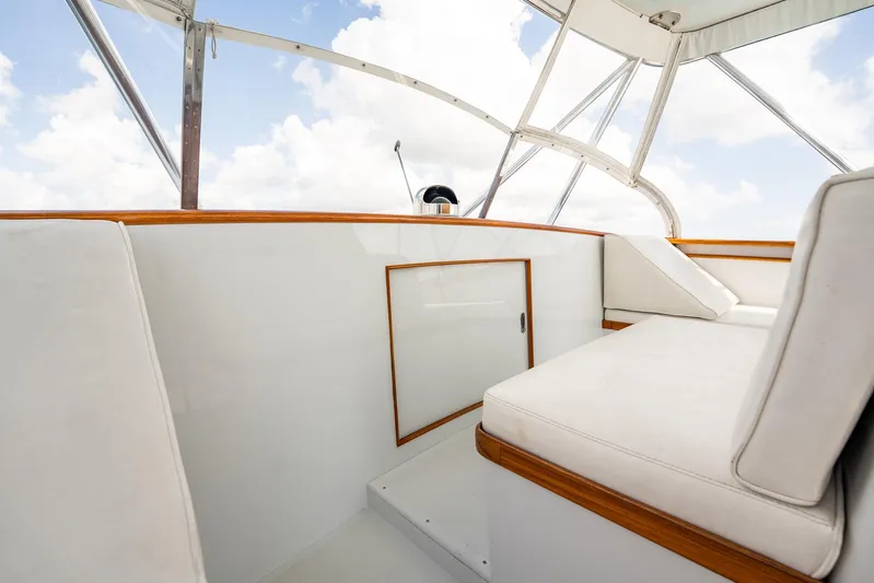 Lucky Yacht Photos Pics 1983 Rybovich 55 Convertible yacht interior with white seating and wooden accents.
