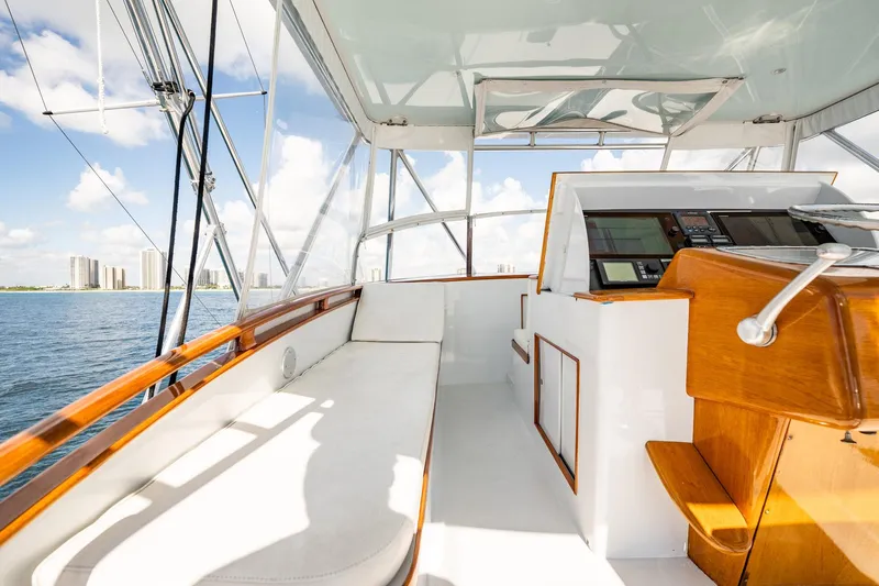 Lucky Yacht Photos Pics 1983 Rybovich 55 Convertible yacht interior with helm, overlooking ocean and city skyline.