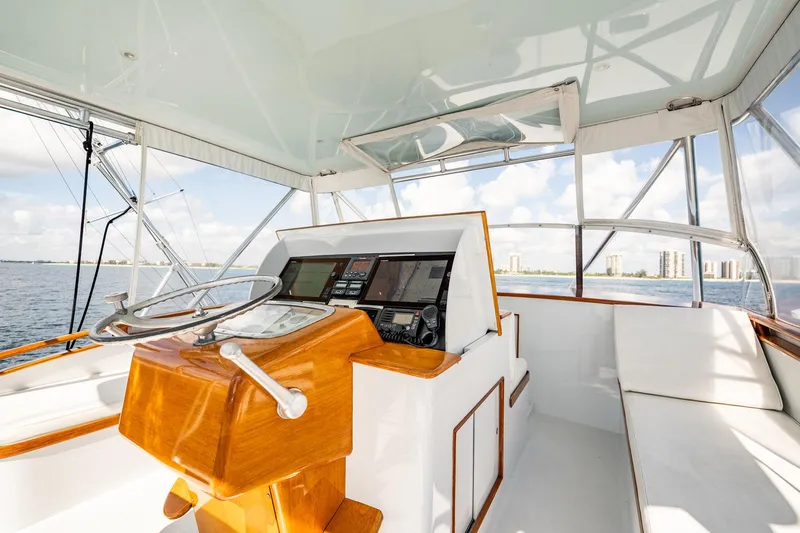 Lucky Yacht Photos Pics 1983 Rybovich 55 Convertible yacht helm with wooden steering and modern navigation.