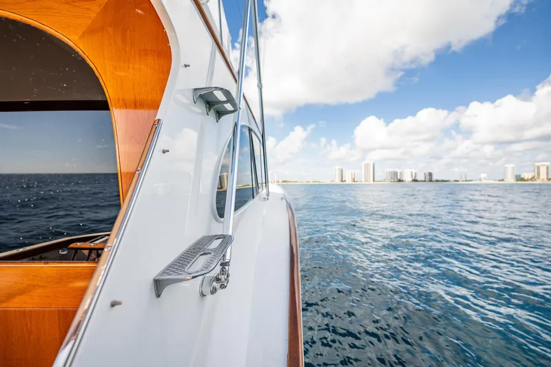 Lucky Yacht Photos Pics 1983 Rybovich 55 Convertible yacht cruising on open water with city skyline.