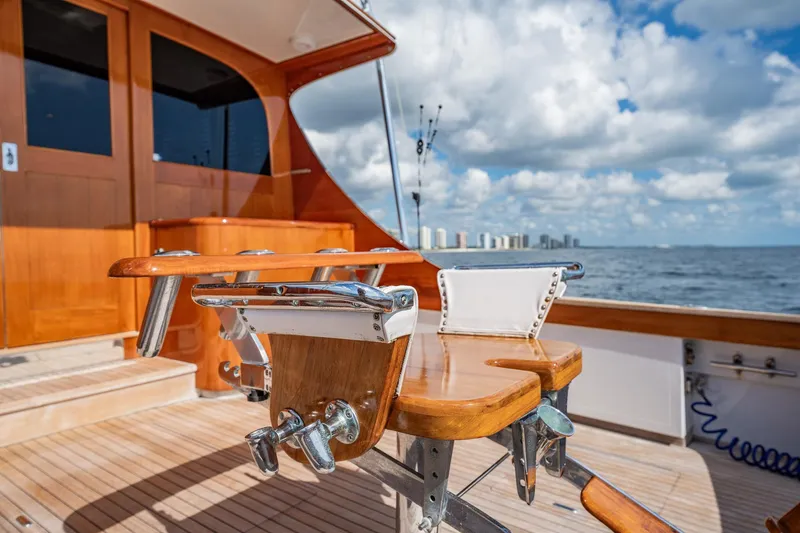 Lucky Yacht Photos Pics 1983 Rybovich 55 Convertible yacht deck with fishing chair, ocean view, and city skyline.