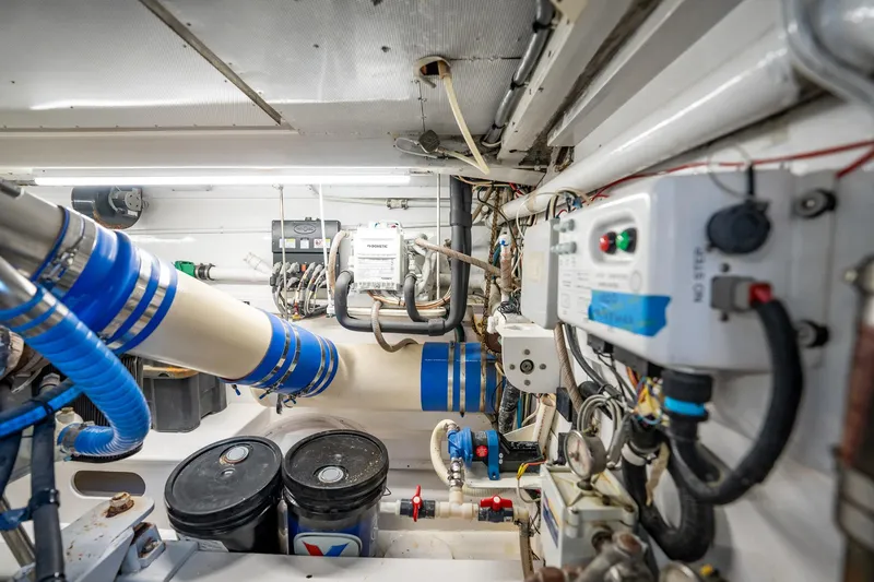 Lucky Yacht Photos Pics Engine room of 1983 Rybovich 55 Convertible yacht with complex machinery and blue piping.