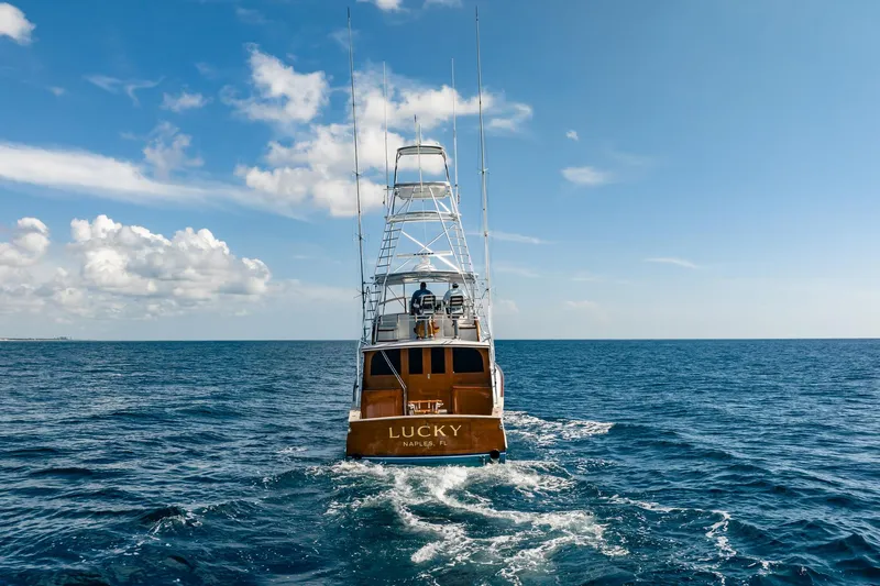 Lucky Yacht Photos Pics 1983 Rybovich 55 Convertible yacht "Lucky" cruising on open ocean under blue sky.