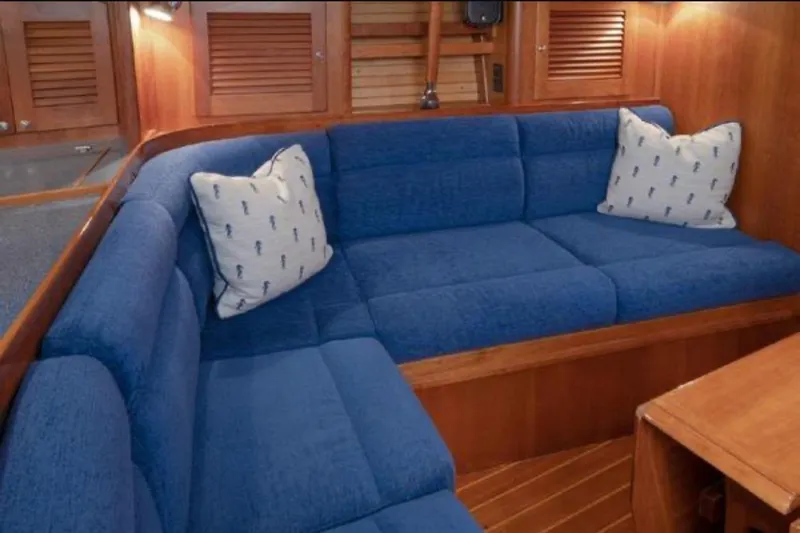 Blue Sky Yacht Photos Pics Cozy blue seating area in 2000 Sabre 402 yacht interior with nautical-themed pillows.