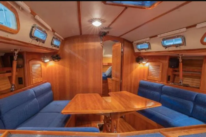 Blue Sky Yacht Photos Pics Interior of 2000 Sabre 402 sailboat with wooden finish and blue seating.