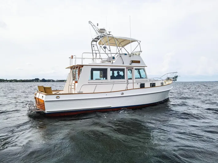 Mystic Yacht Photos Pics 1989 Grand Banks 36 Sedan boat on open water, side view.