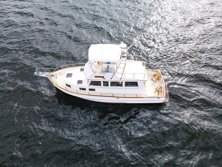 Mystic Yacht Photos Pics 1989 Grand Banks 36 Sedan cruising on open water, aerial view.