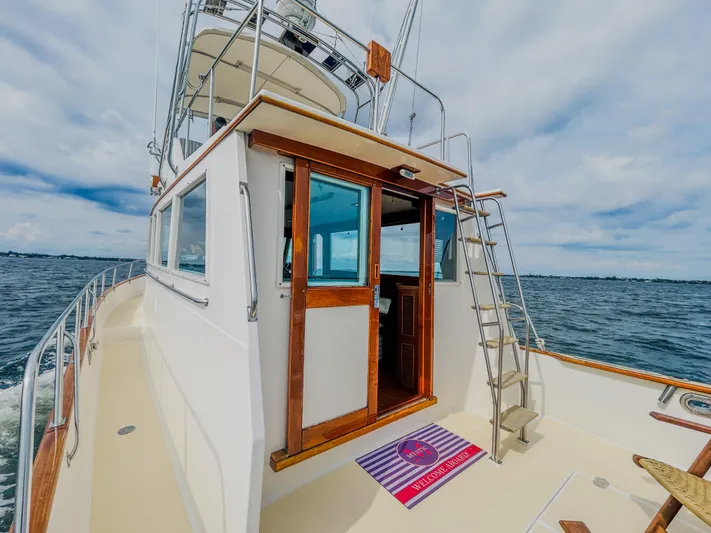Mystic Yacht Photos Pics 1989 Grand Banks 36 Sedan yacht on open water, featuring wooden accents and ladder.
