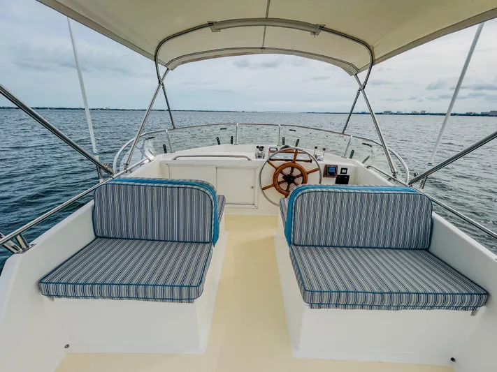 Mystic Yacht Photos Pics 1989 Grand Banks 36 Sedan boat interior with striped seating and wooden steering wheel.