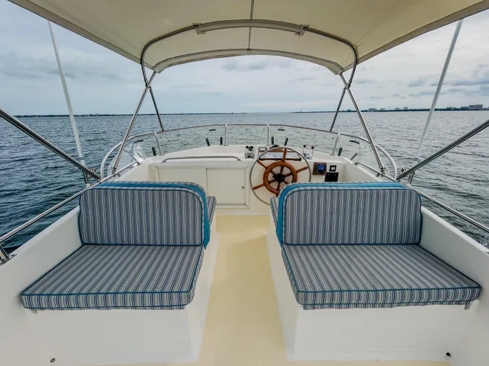 Mystic Yacht Photos Pics 1989 Grand Banks 36 Sedan boat interior with striped seating and wooden steering wheel.